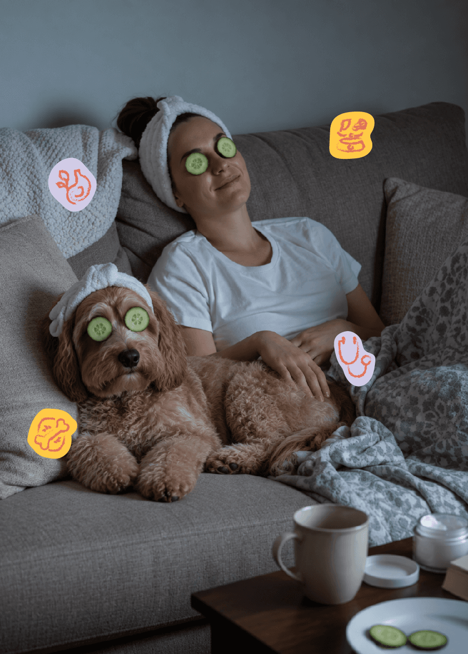 A woman and her golden doodle relaxing on a sofa in matching spa headbands, cucumber slices over their eyes